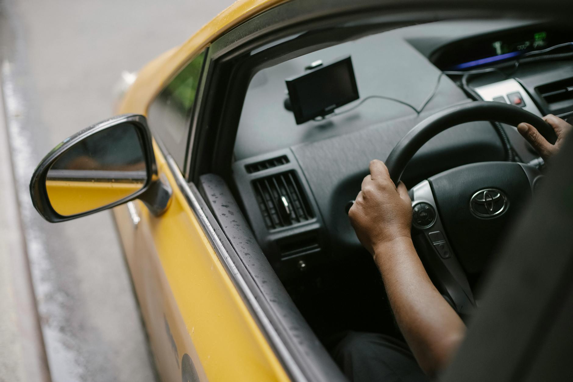 faceless person driving contemporary cab in city