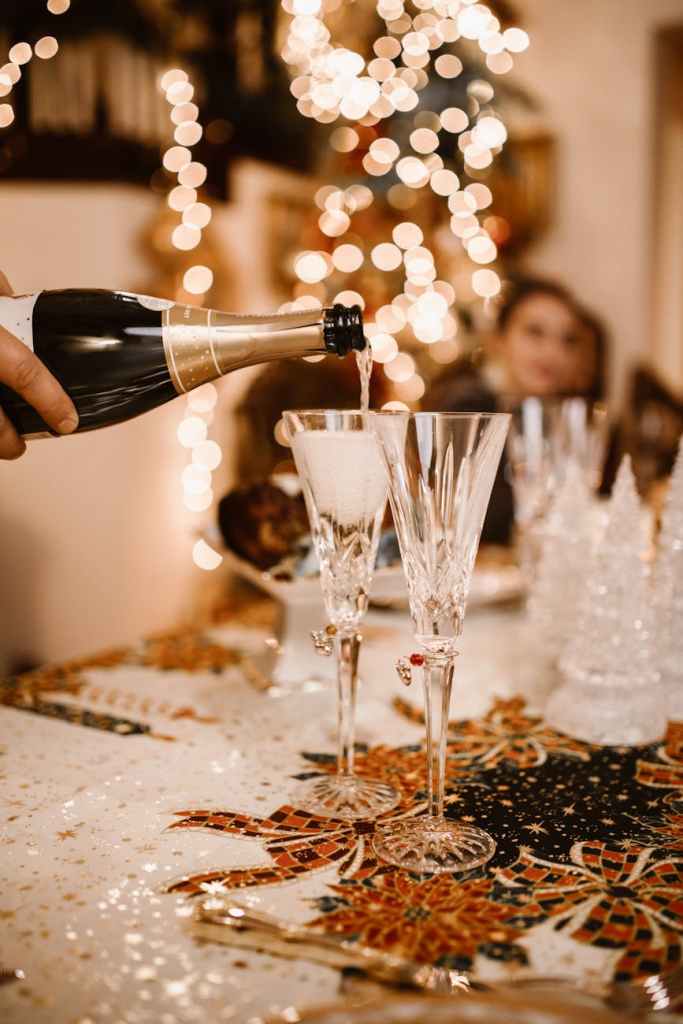 person pouring champagne on the glass
