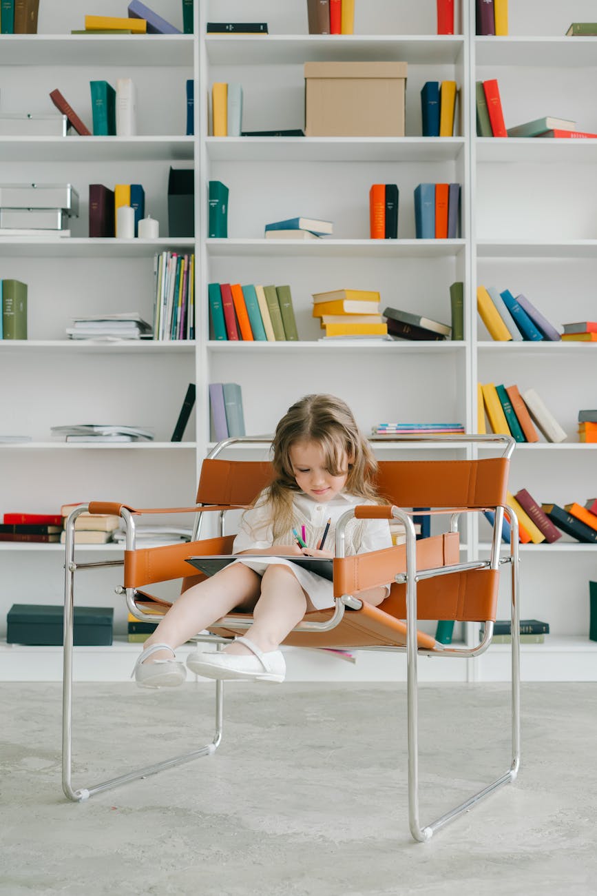 a girl in white dress sitting on a chair