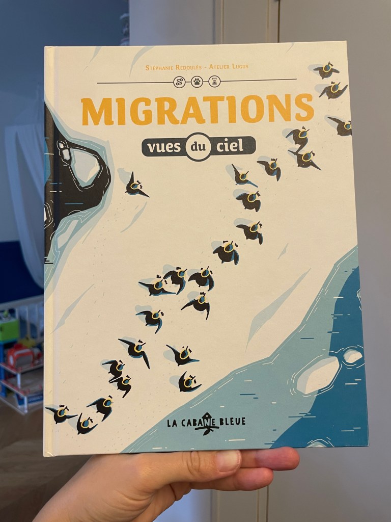 Couverture d'un livre intitulé 'Migrations vues du ciel' avec des illustrations d'oiseaux en vol, tenu par une main.