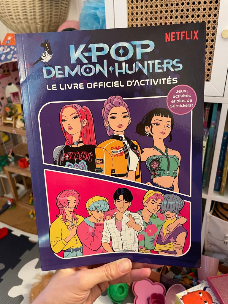 Couverture du livre officiel d'activités 'KPOP Demon Hunters' de Netflix, mettant en vedette plusieurs personnages de style manga, avec des jeux, des activités et des stickers.